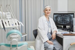 Dentist in modern office with dental chair and X-ray display, representing factors that influence dental practice value.